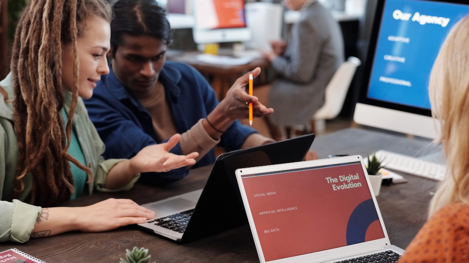 An agency team working together at laptops