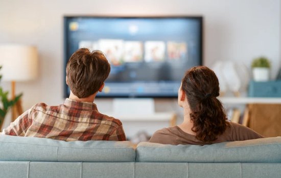 A couple on a sofa watching a streaming TV home screen